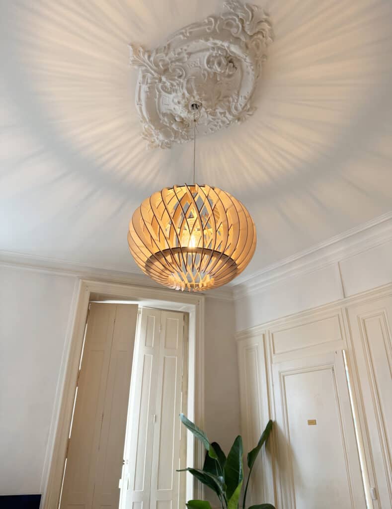 Luminaire artisanal en bois suspendu dans un salon