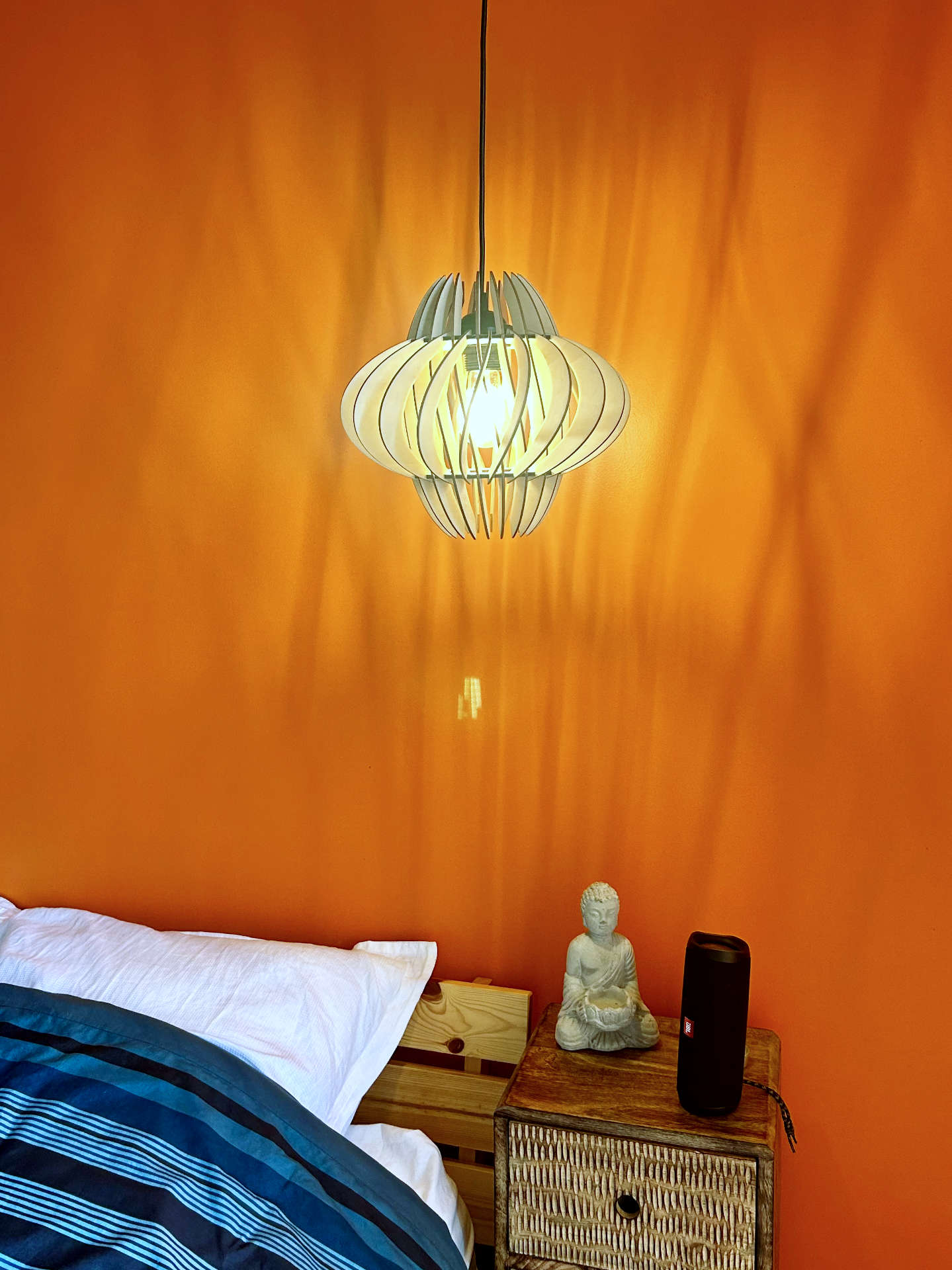 Un lustre en bois qui projette de belles ombres au mur