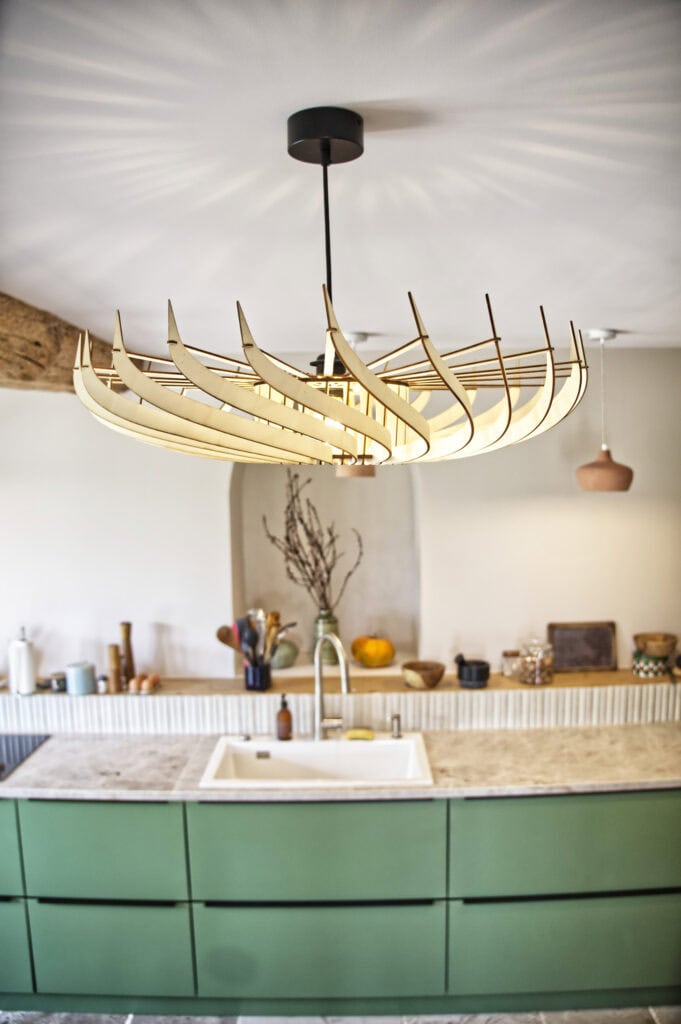 Suspension bois Claudine la turbine éclairant une cuisine ouverte aux murs en bois