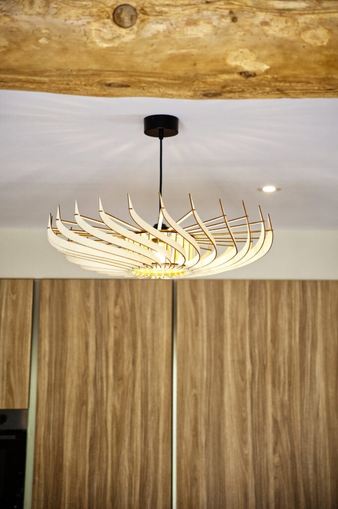 Suspension en bois Claudine la turbine au-dessus d'un meuble dans un intérieur lambrissé