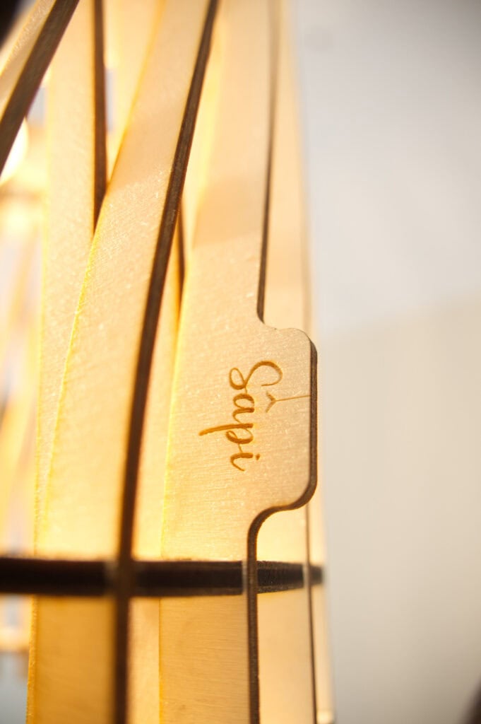 Détail du bois et de la signature Sâpi sur la suspension Vincent l'incandescent
