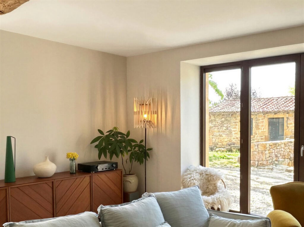 Lampadaire bois Léon L'accordéon éclairant un coin lecture près d'une fenêtre