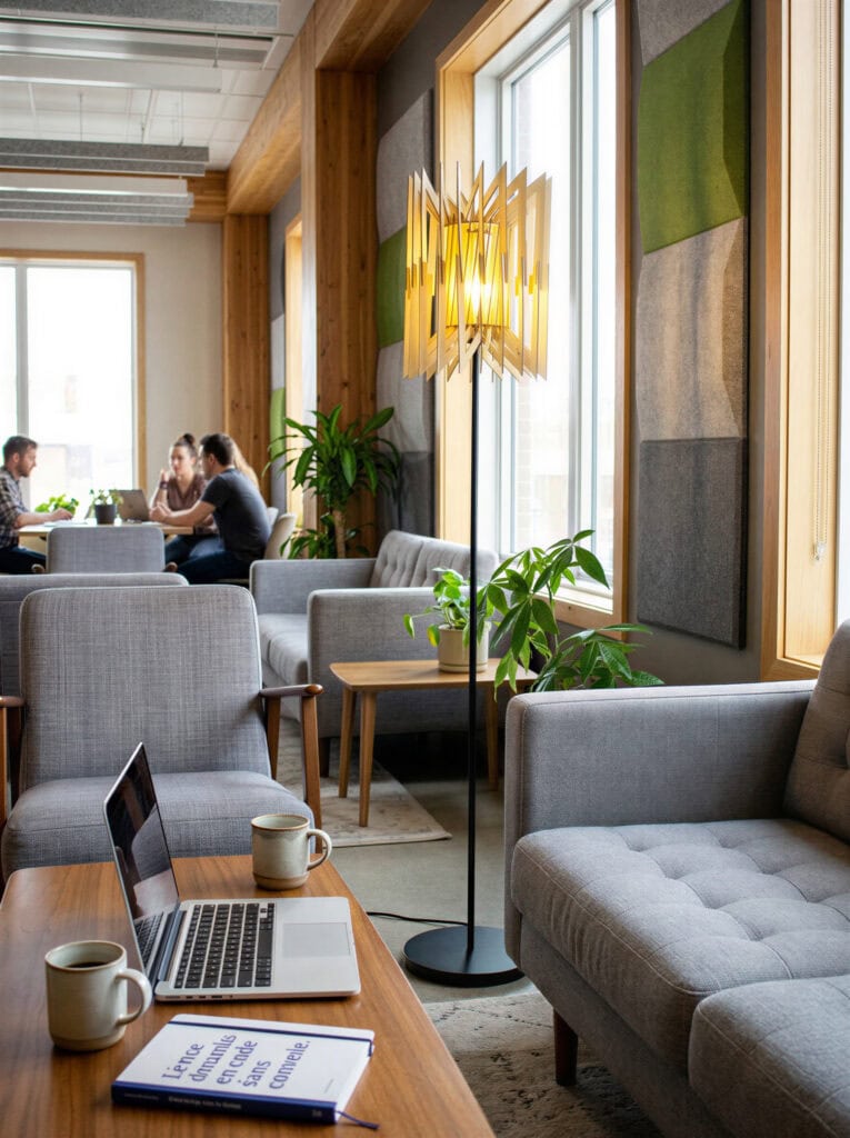 Lampadaire bois Léon L'accordéon allumé près d'un fauteuil dans un salon douillet