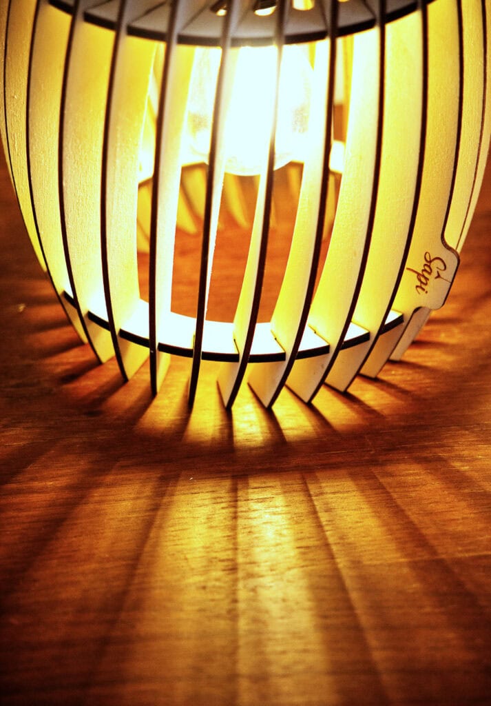 Zoom sur une lampe à poser déco en bois, posée sur un meuble en bois