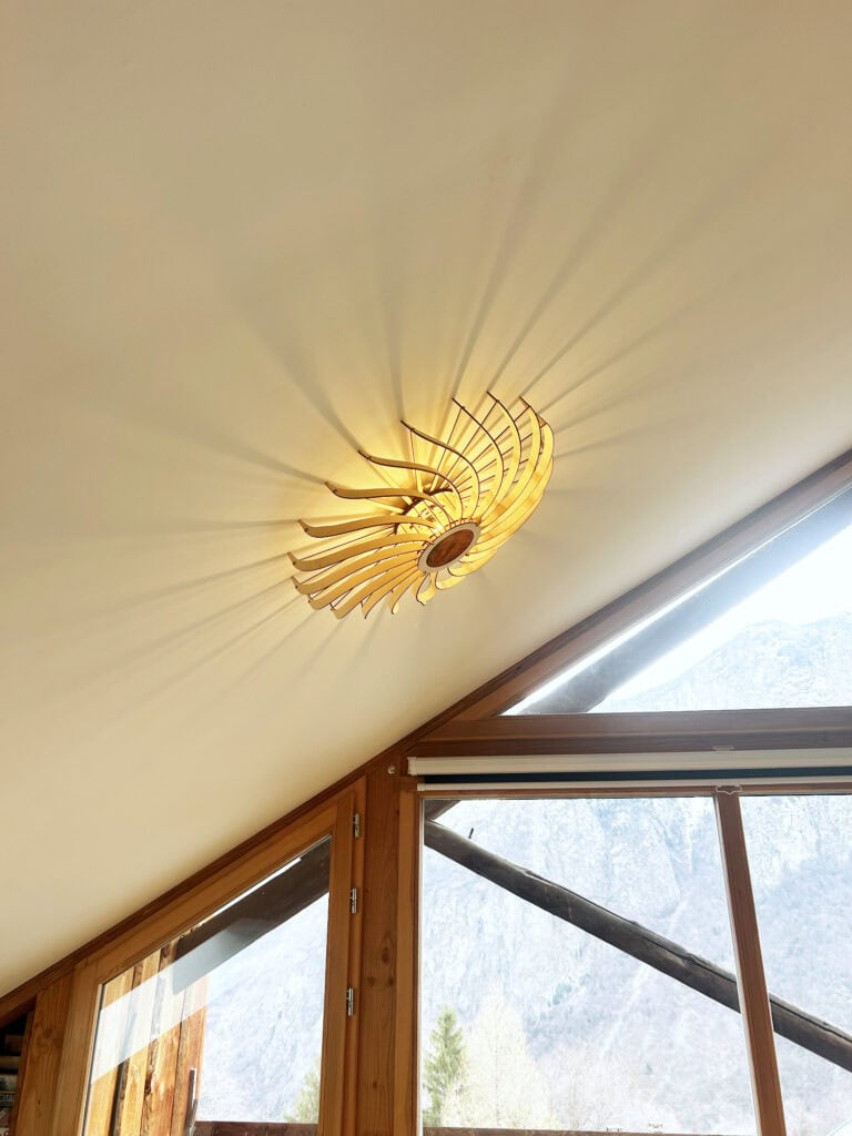 Applique murale en bois Olivia sous un plafond mansardé, près d'une fenêtre