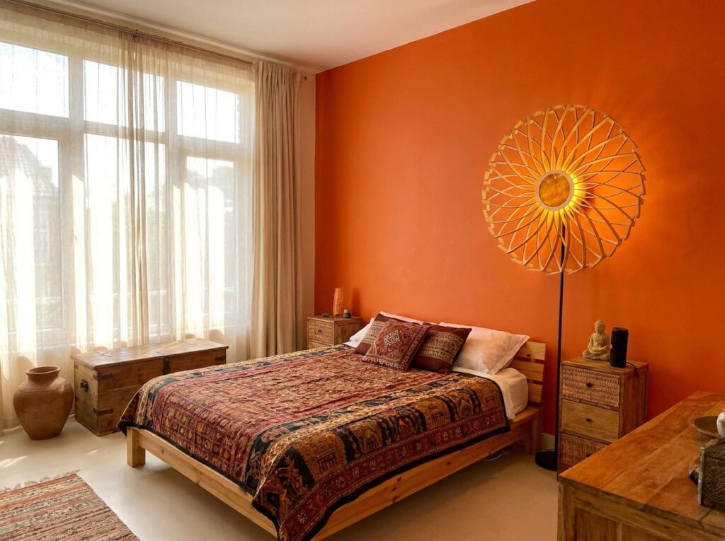 Lampadaire bois Charlie dans une chambre orange, près d'une fenêtre