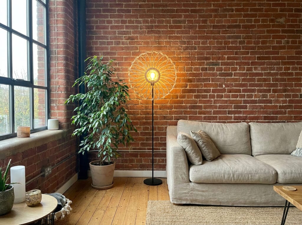 Lampadaire bois Charlie dans un salon loft au mur de briques