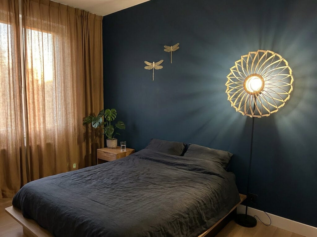 Lampadaire bois Charlie dans une chambre au mur bleu nuit