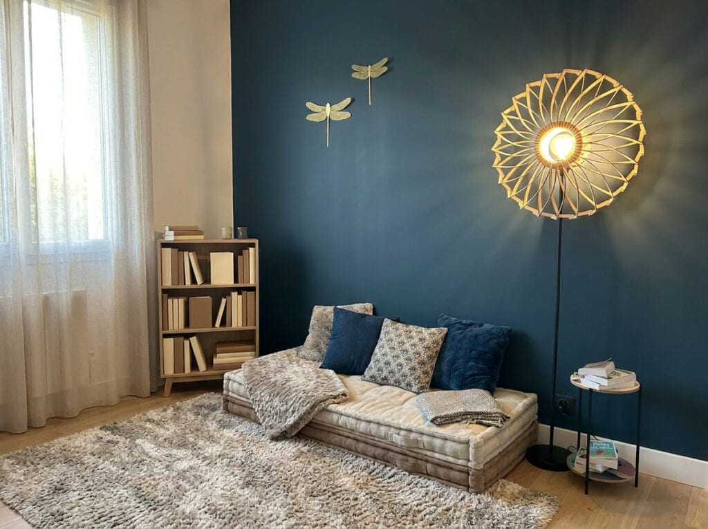Lampadaire en bois Charlie dans une chambre au mur bleu