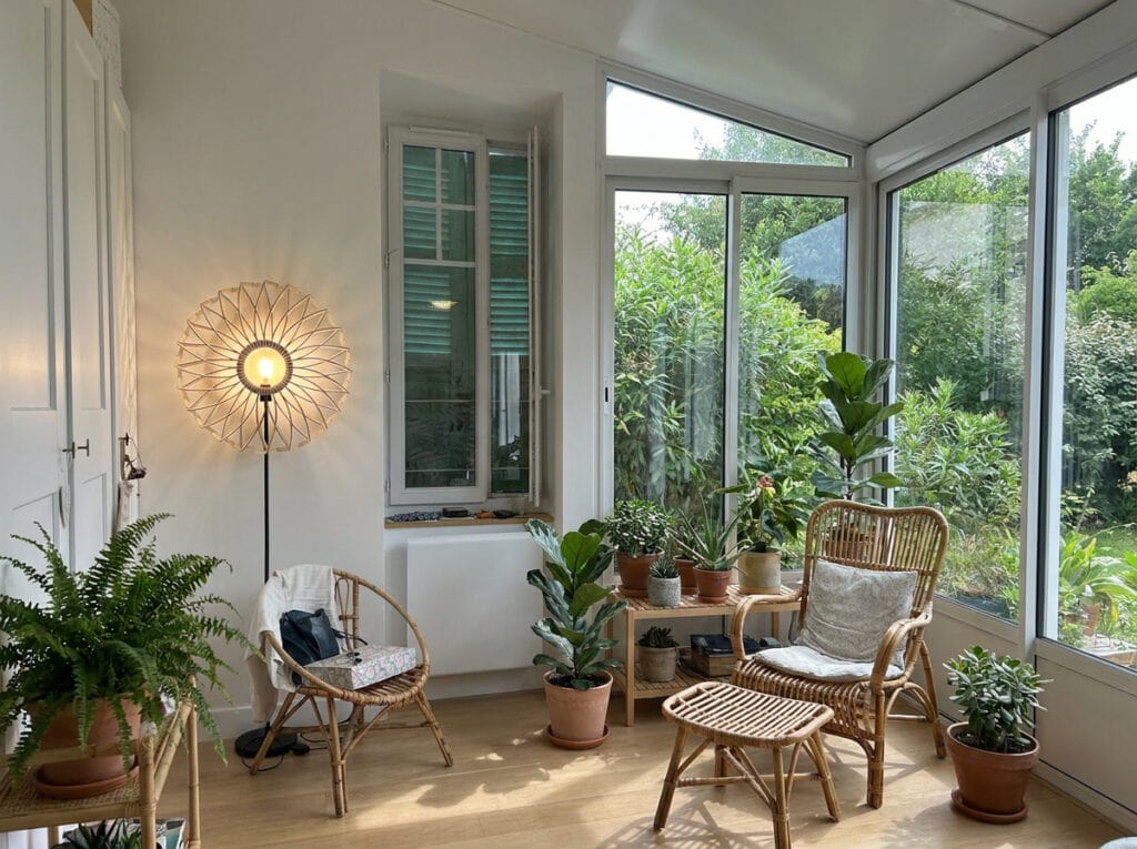 Lampadaire bois Charlie dans une véranda entourée de plantes