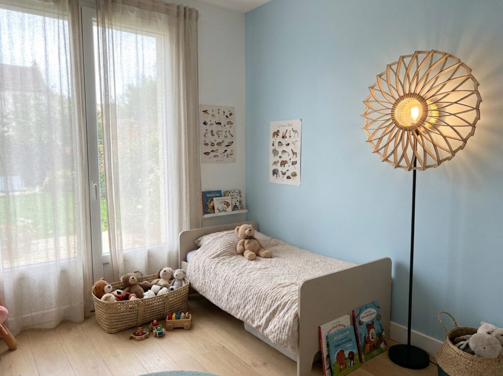 Lampadaire en bois Charlie dans une chambre au mur bleu clair