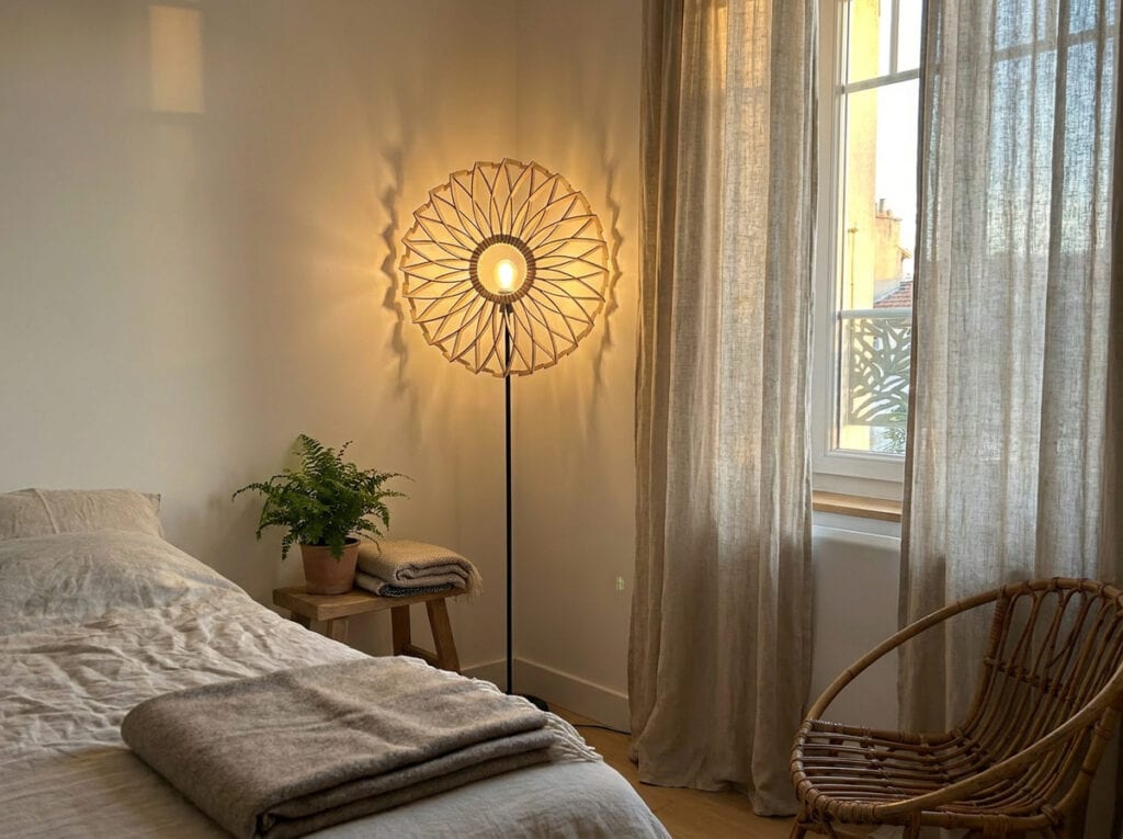 Lampadaire en bois Charlie dans un salon, canapé vert près d'une porte
