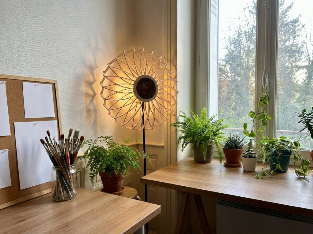 Lampadaire en bois Charlie dans un bureau, entouré de plantes