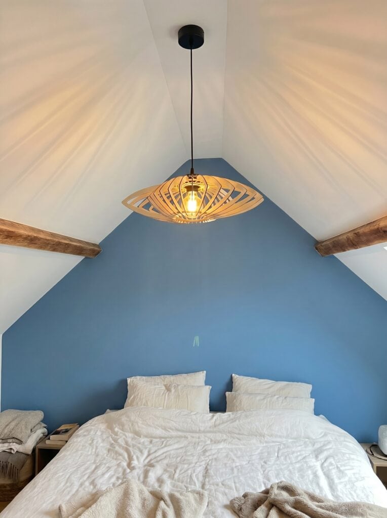 Suspension bois Sébastien Le marin au-dessus d'un lit dans une chambre au mur bleu
