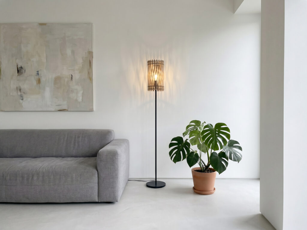 Lampadaire bois Vincent allumé dans un intérieur épuré, à côté d'un fauteuil
