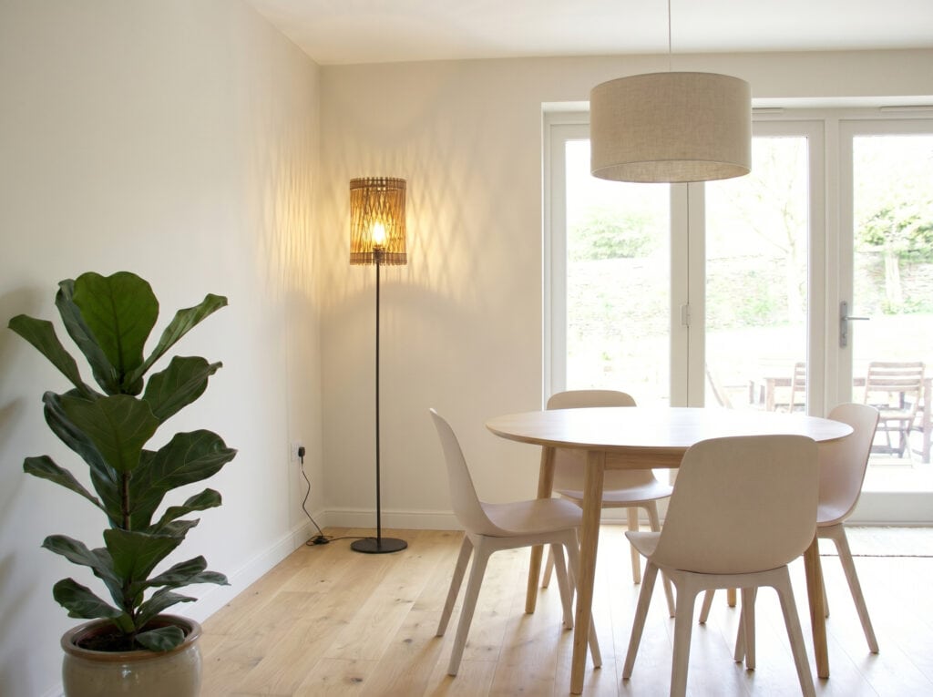 Lampadaire en bois Vincent dans un coin repas lumineux, près de la table