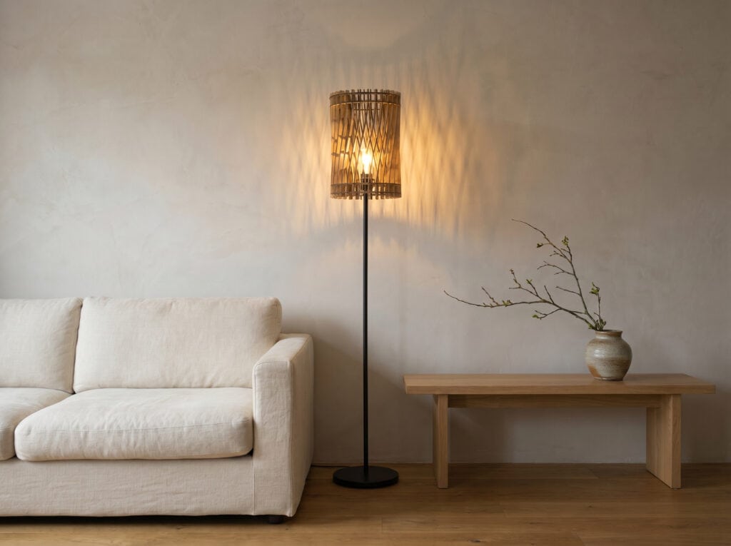 Lampadaire bois Vincent dans un intérieur chaleureux, à côté d'une assise